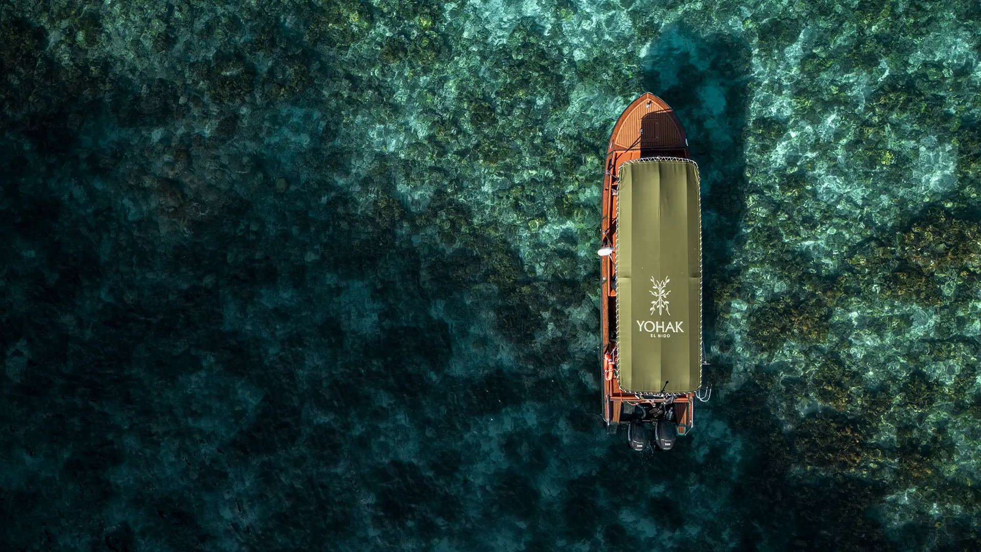 Aerial view of the YOHAK luxury speedboat in El Nido's coral-filled waters.
