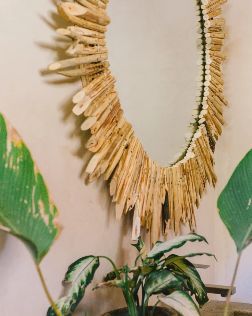 Handcrafted driftwood sunburst mirror and tropical plants at Parada Beach Camp Palawan