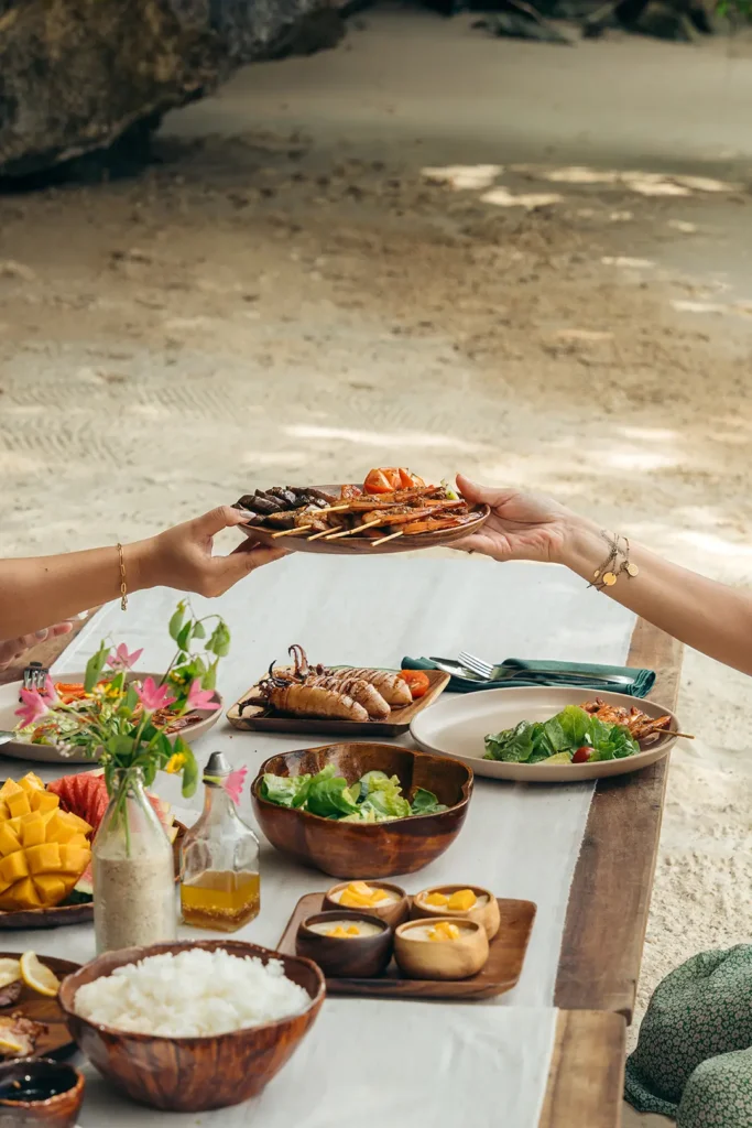 Guests sharing a freshly prepared beach picnic during a Yohak Palawan expedition
