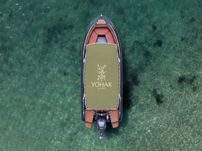 Aerial view of a Yohak El Nido speedboat floating over clear turquoise water, used for shared island tours in Palawan.